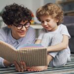 Volwassene leest samen met een peuter een prentenboek